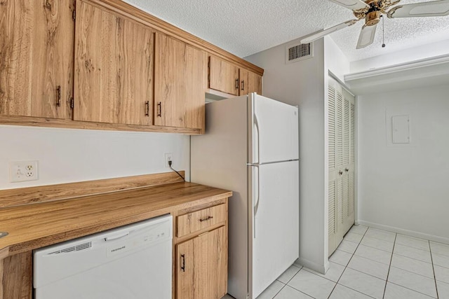 kitchen with white appliances, light tile patterned floors, visible vents, and a textured ceiling