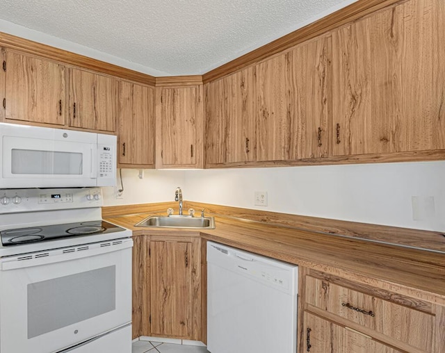 kitchen featuring a textured ceiling, white appliances, and a sink