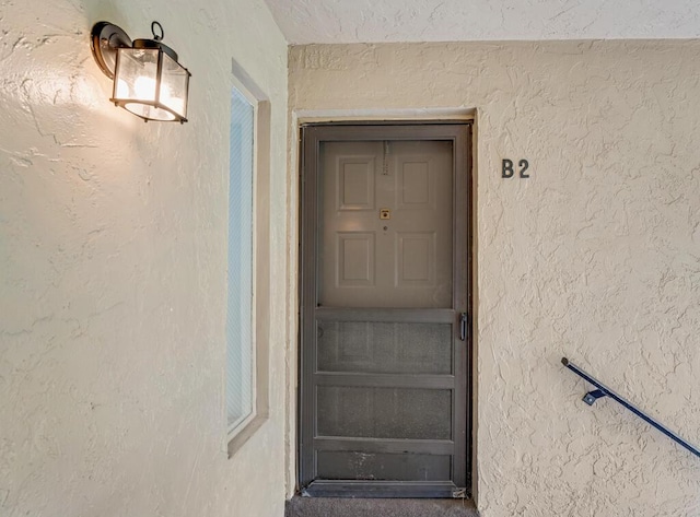 entrance to property featuring stucco siding