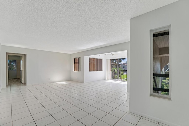 empty room with light tile patterned floors and a textured ceiling