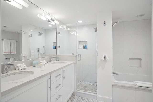 bathroom with a washtub, a sink, a shower stall, and double vanity