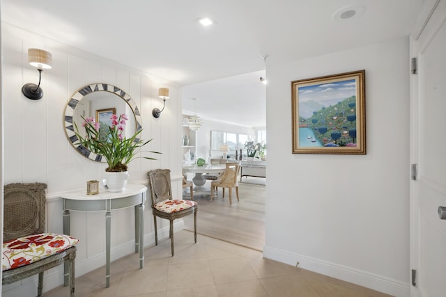 corridor featuring baseboards and light tile patterned flooring