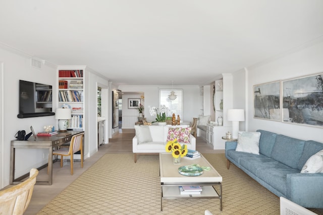 living room featuring light wood-style floors, visible vents, and crown molding