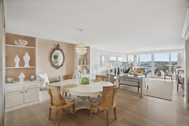 dining room featuring light wood-style floors and crown molding