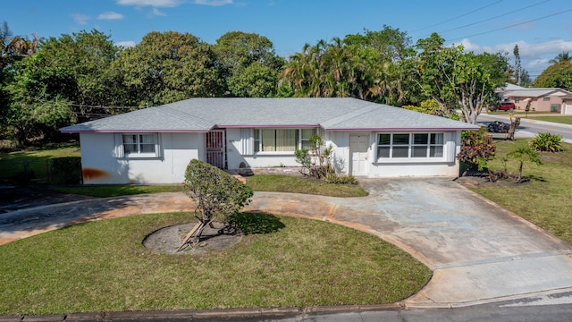 single story home with a shingled roof, concrete driveway, and a front yard