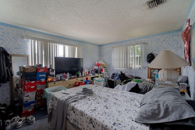 bedroom with wallpapered walls, multiple windows, visible vents, and a textured ceiling