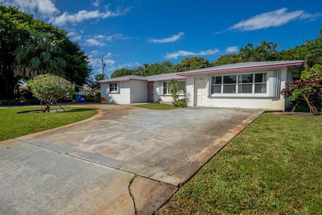 ranch-style house with driveway, a front lawn, and stucco siding