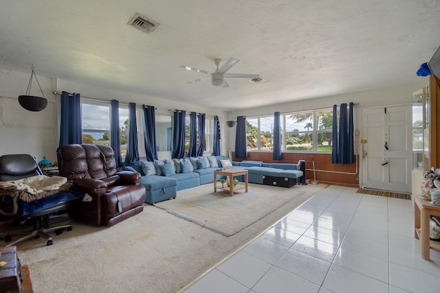 living room with a ceiling fan, visible vents, and tile patterned floors