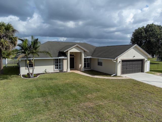 ranch-style home featuring a garage, a front yard, driveway, and stucco siding