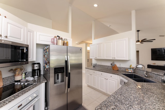 kitchen featuring light tile patterned floors, appliances with stainless steel finishes, a sink, and white cabinets