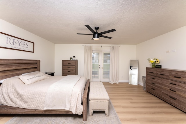 bedroom featuring a textured ceiling, ceiling fan, light wood-style flooring, access to outside, and french doors