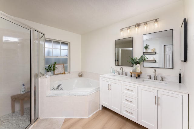 full bathroom featuring double vanity, a sink, a bath, and a shower stall