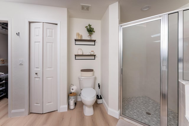 full bath with toilet, a closet, a shower stall, and visible vents