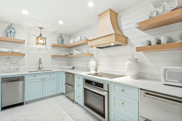 kitchen featuring open shelves, appliances with stainless steel finishes, a sink, and custom range hood