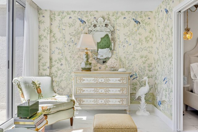 sitting room with baseboards, marble finish floor, and wallpapered walls