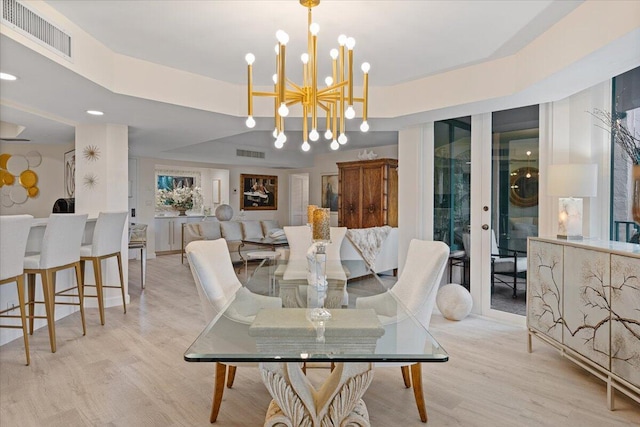 dining space with an inviting chandelier, wood finished floors, and visible vents