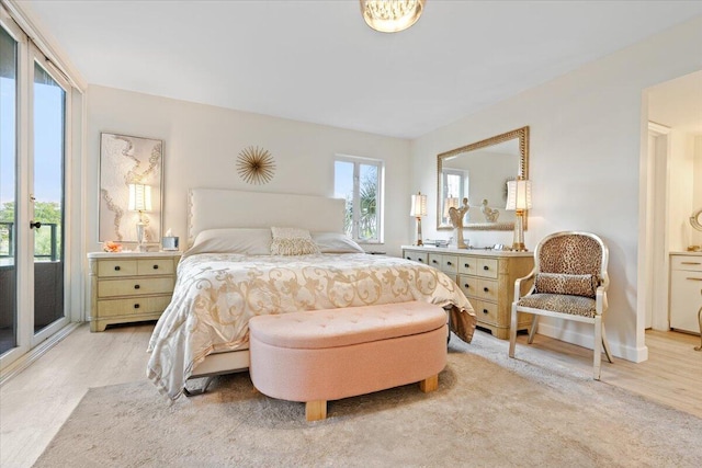 bedroom featuring access to exterior and light wood-style flooring