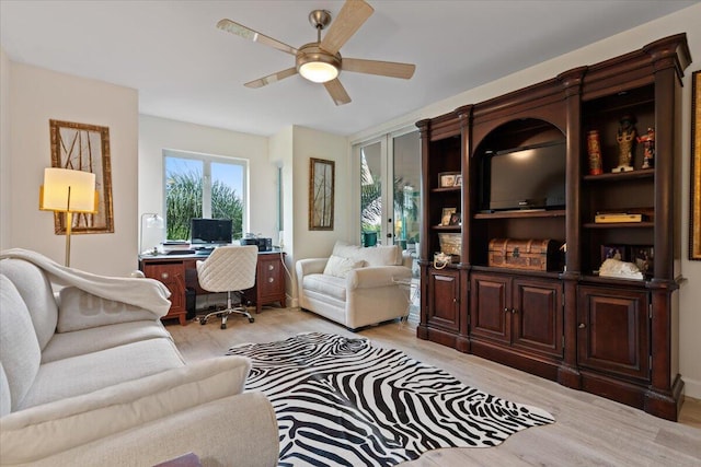 living area with ceiling fan and light wood finished floors