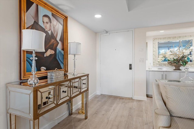 foyer with recessed lighting, light wood-type flooring, and baseboards