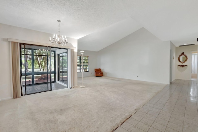 carpeted empty room featuring a notable chandelier, a textured ceiling, and lofted ceiling