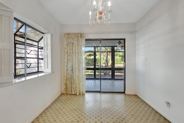 empty room featuring tile patterned floors, baseboards, and an inviting chandelier