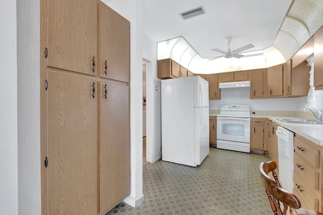 kitchen featuring white appliances, visible vents, a sink, light countertops, and under cabinet range hood