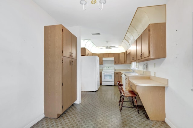 kitchen featuring under cabinet range hood, light floors, light countertops, white appliances, and a sink