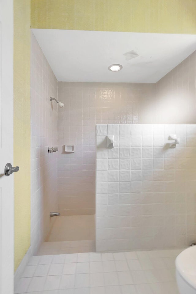 bathroom featuring tiled shower and toilet