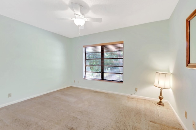 carpeted empty room with baseboards and ceiling fan