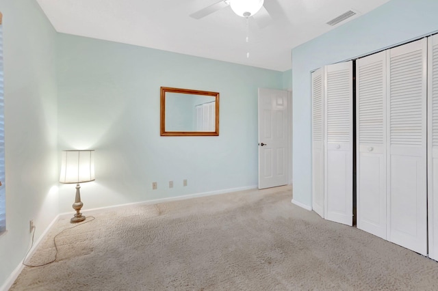 unfurnished bedroom featuring a ceiling fan, baseboards, visible vents, carpet floors, and a closet