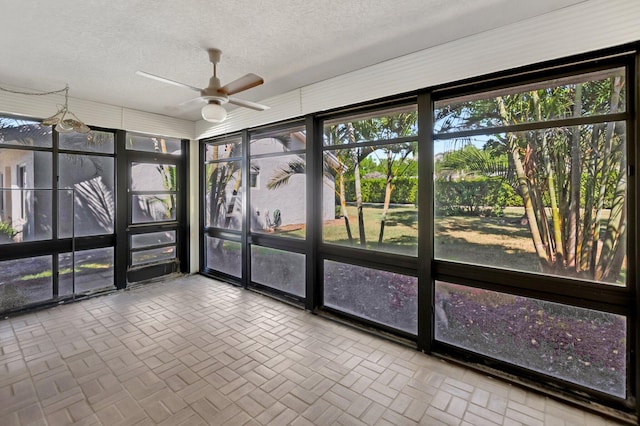 unfurnished sunroom featuring ceiling fan