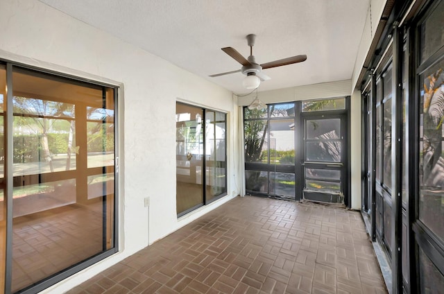 unfurnished sunroom featuring a wealth of natural light and ceiling fan