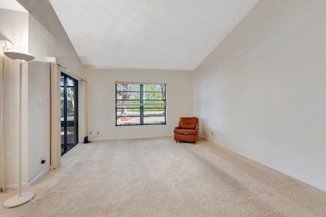 unfurnished room with light carpet, baseboards, and lofted ceiling