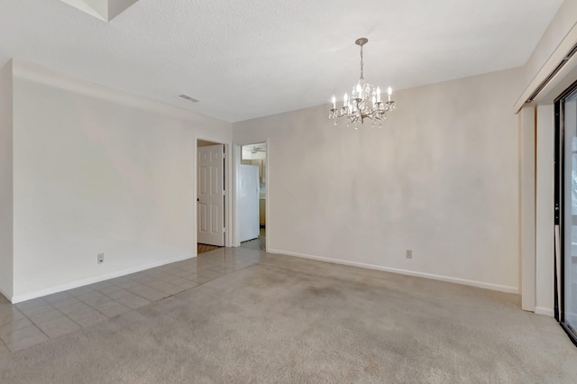 empty room with baseboards, visible vents, carpet floors, a textured ceiling, and a notable chandelier