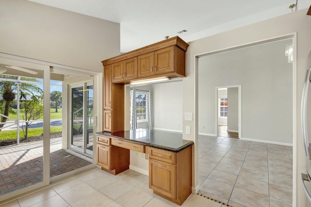 kitchen with visible vents, brown cabinets, a ceiling fan, light tile patterned floors, and baseboards