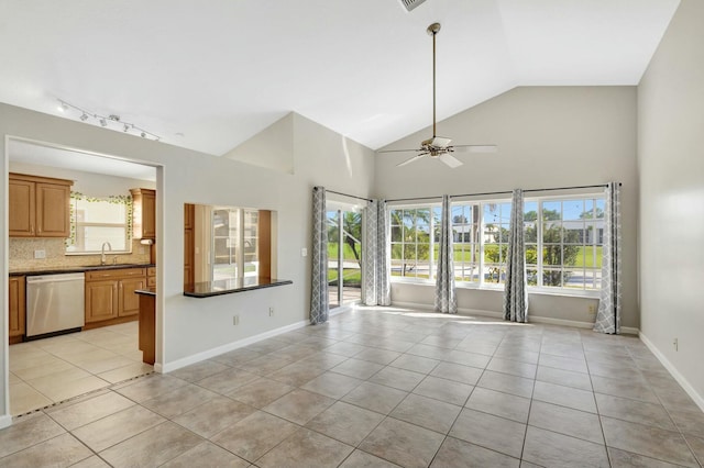 interior space featuring light tile patterned floors, baseboards, a wealth of natural light, and a sink