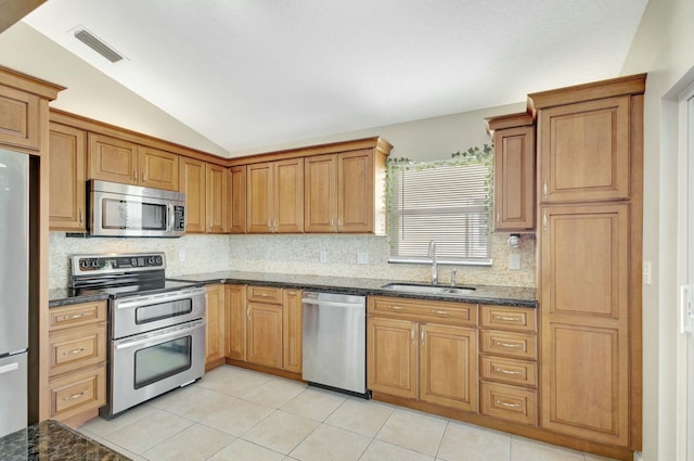 kitchen with visible vents, light tile patterned flooring, a sink, stainless steel appliances, and vaulted ceiling