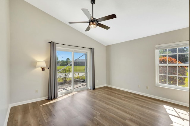 spare room featuring a ceiling fan, vaulted ceiling, wood finished floors, and baseboards