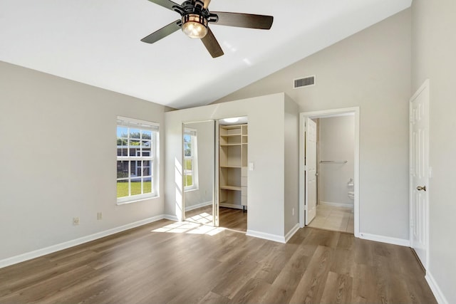 unfurnished bedroom with connected bathroom, wood finished floors, visible vents, and baseboards