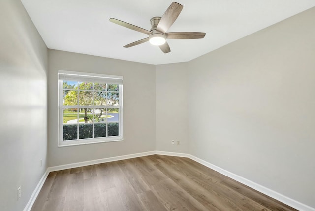 spare room featuring a ceiling fan, baseboards, and wood finished floors