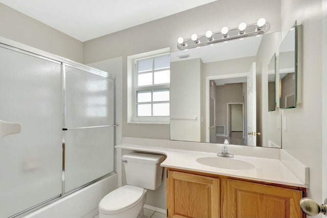 full bath featuring combined bath / shower with glass door, toilet, and vanity