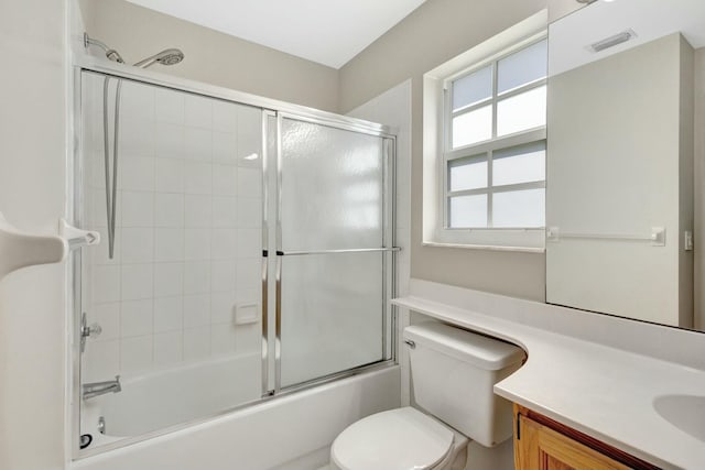 bathroom with vanity, toilet, visible vents, and enclosed tub / shower combo