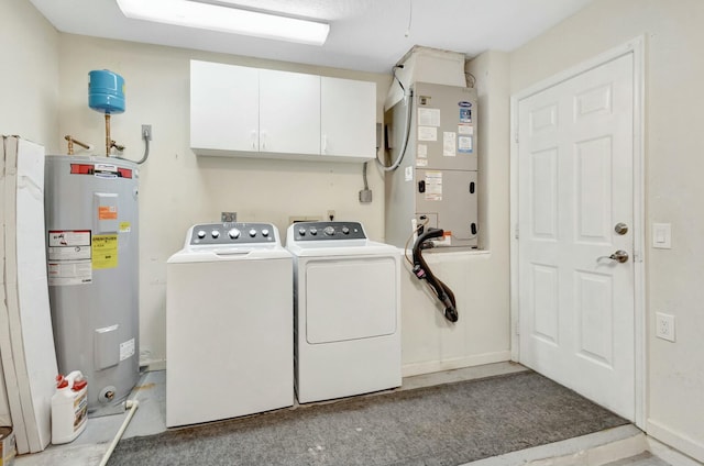 washroom with heating unit, cabinet space, water heater, and washer and clothes dryer