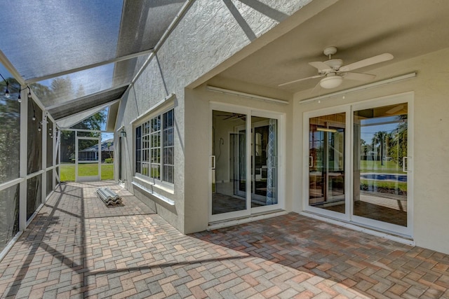 unfurnished sunroom featuring a ceiling fan