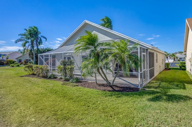 rear view of house with a yard and a lanai