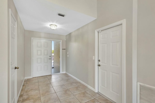 entryway featuring light tile patterned flooring, baseboards, and visible vents