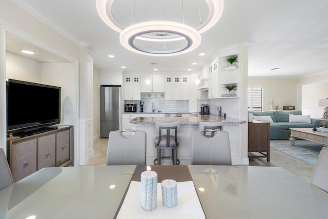 dining space featuring light tile patterned floors, a tray ceiling, recessed lighting, and crown molding