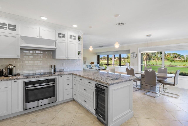 kitchen with visible vents, premium range hood, a peninsula, wine cooler, and stainless steel oven