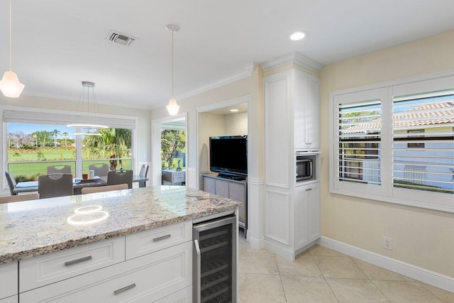 kitchen with decorative light fixtures, visible vents, beverage cooler, and white cabinetry