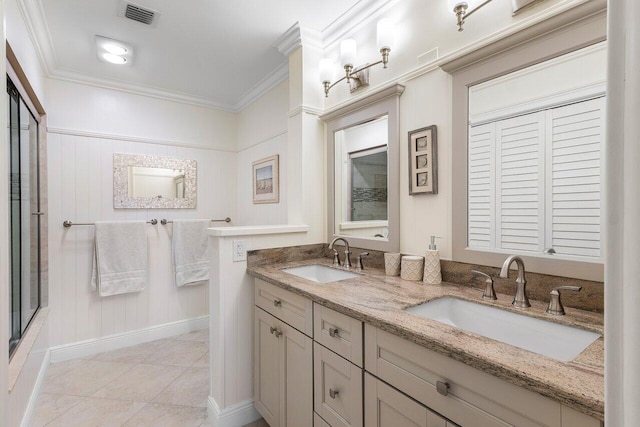 bathroom featuring a sink, visible vents, a shower with door, and crown molding